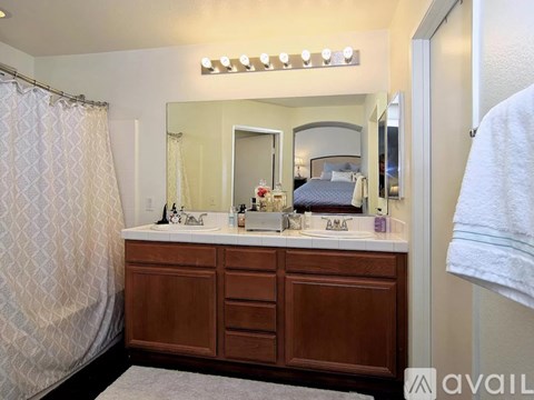 A bathroom with a vanity and a mirror above it.