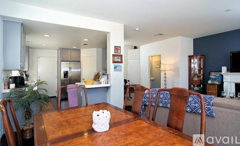 A modern kitchen with a wooden table and chairs in the foreground.