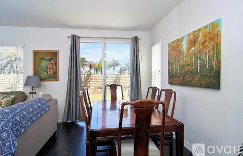 A dining room with a wooden table and chairs.