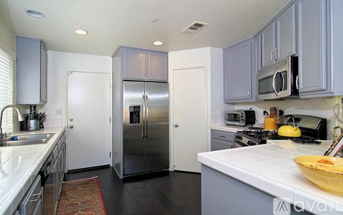 A kitchen with a refrigerator, microwave, and oven.