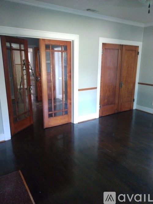 A room with a wooden floor and two doors.
