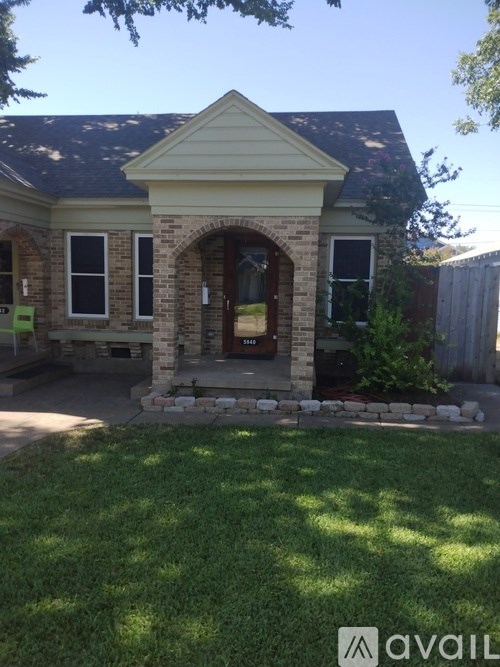 A house with a stone archway entrance and a small front yard.