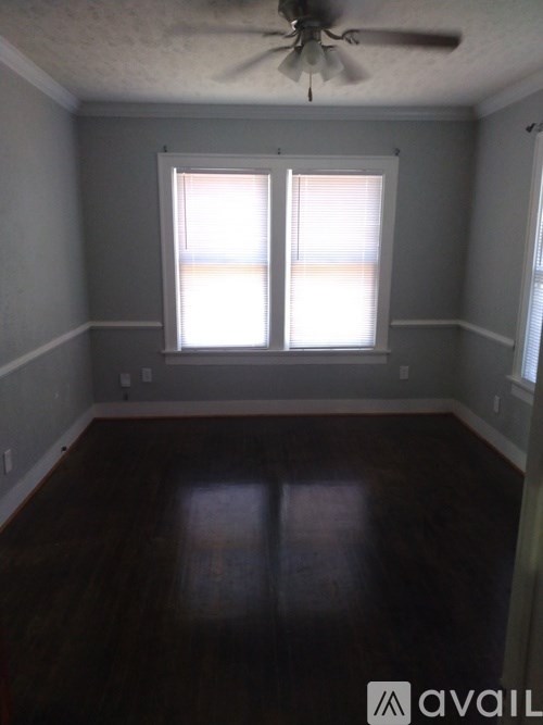 A room with a ceiling fan and a window with blinds.