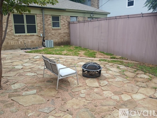 A patio with a chair and a fire pit.