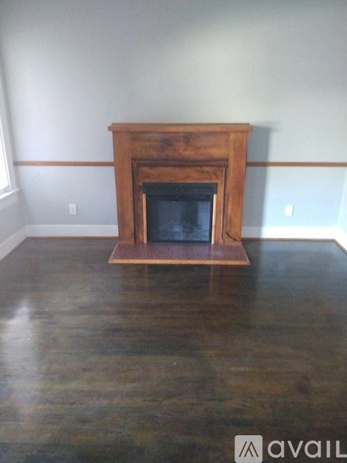 A wood fireplace in a room with a wooden floor.
