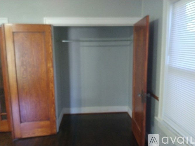 A room with a wooden door and a window with blinds.