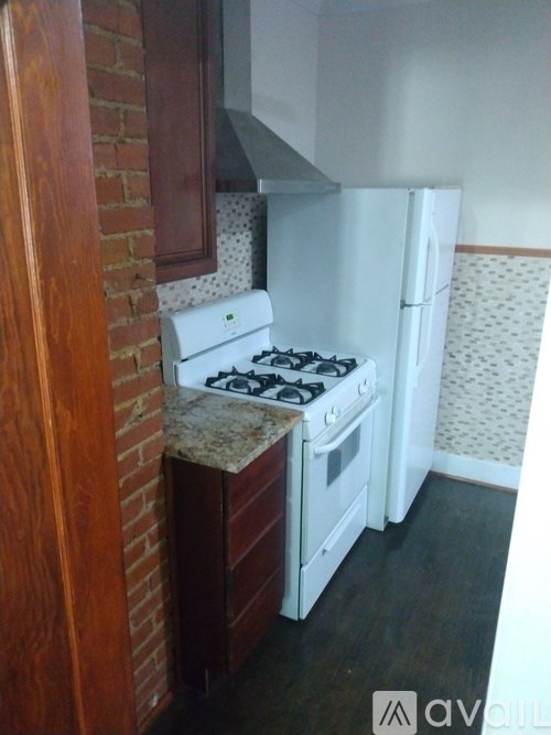 A kitchen with a white stove and a white fridge.
