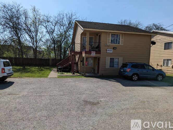 A two-story house with a garage and a car parked in front.