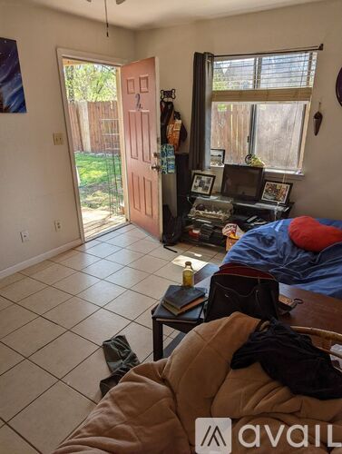 A room with a bed, a couch, and a table with various items on it.