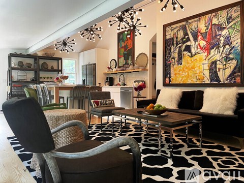 A modern living room with a large abstract painting on the wall.