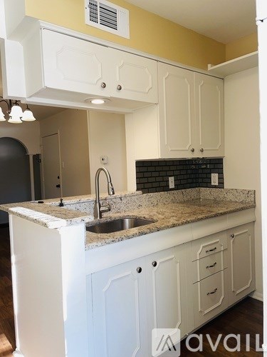 A kitchen with white cabinets and a granite countertop.