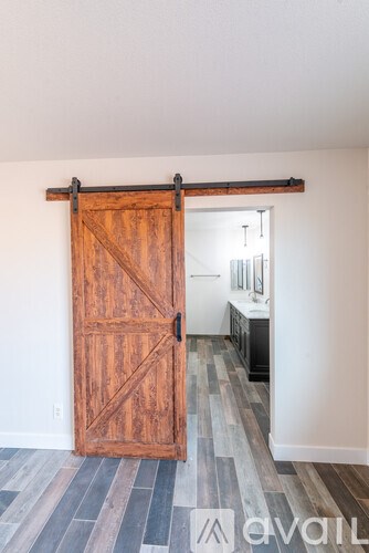 A large wooden door with a black handle is open.