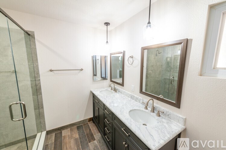 A bathroom with a marble countertop and a walk-in shower.