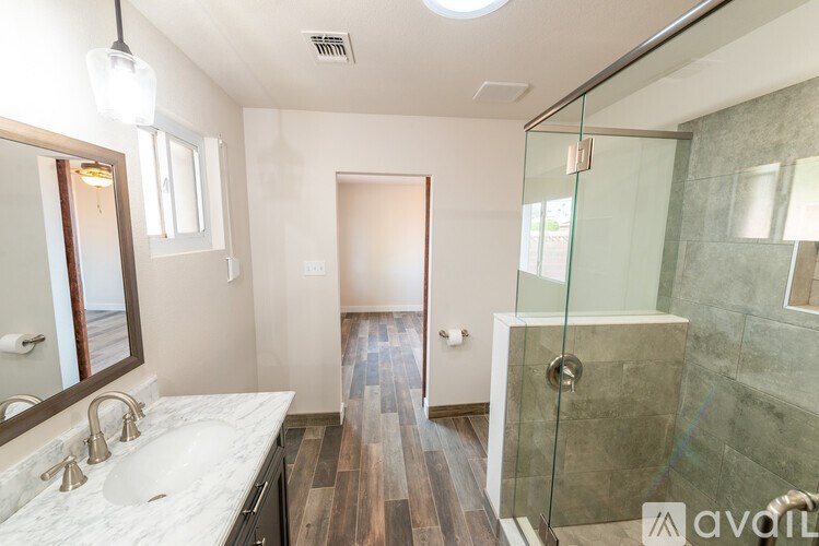 A bathroom with a marble countertop and a walk-in shower.