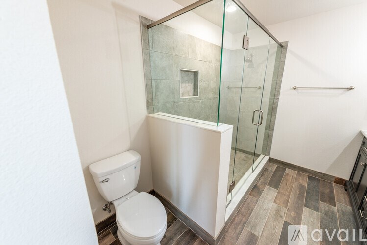 A white toilet sits next to a walk-in shower with a glass door.