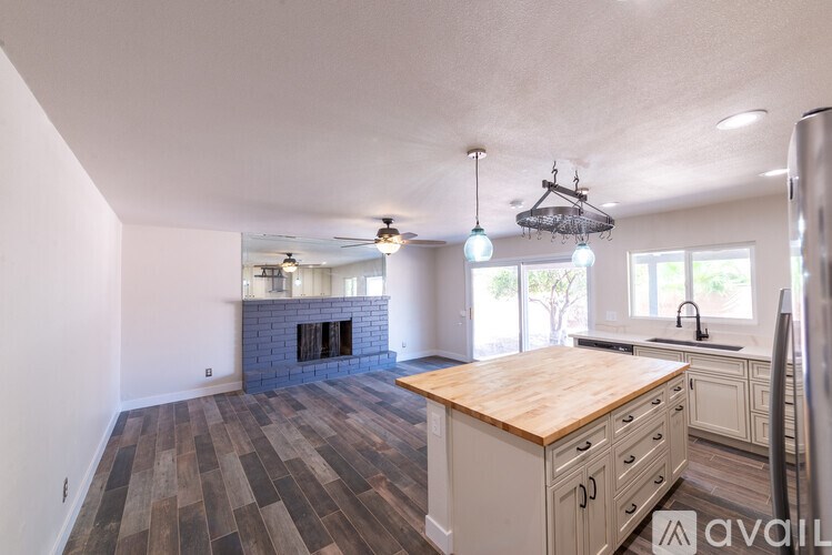 A kitchen with a wooden countertop and a fireplace.