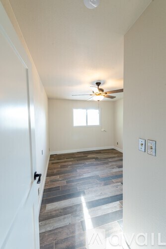 A room with a ceiling fan and a window.