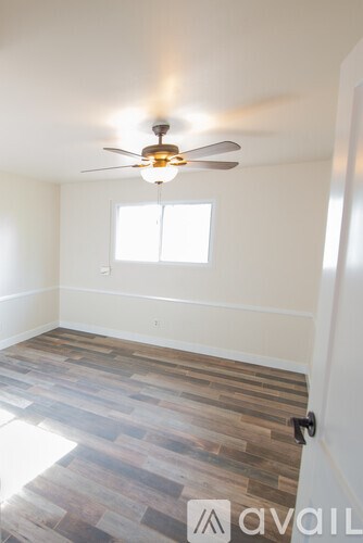 A room with a ceiling fan and a window.