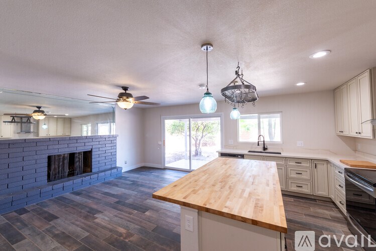 A kitchen with a wooden countertop and a brick fireplace.