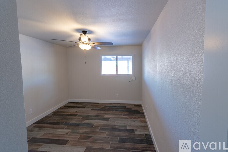 A room with a ceiling fan and a window.