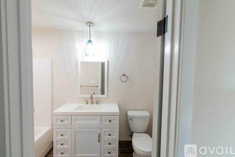 A bathroom with a white sink, toilet, and bathtub.