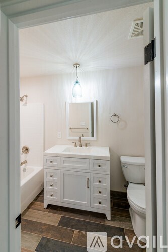 A bathroom with a white vanity and a white toilet.