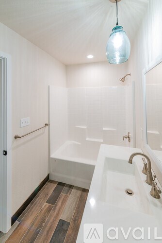 A bathroom with a white sink and a white bathtub.