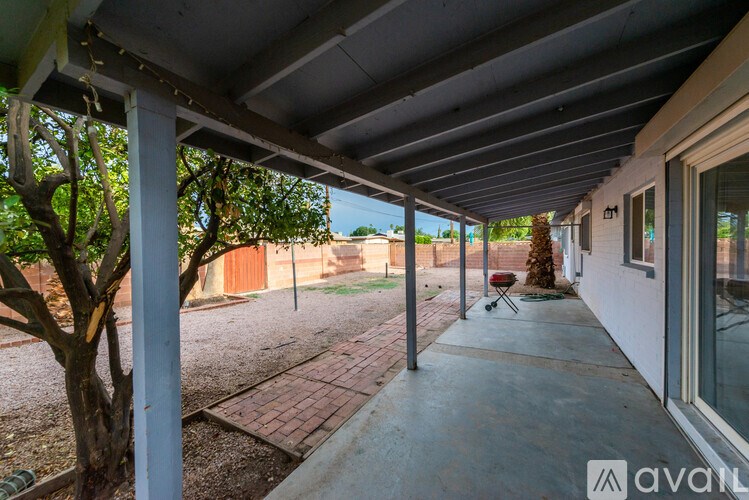 A patio area with a tree and a brick pathway.