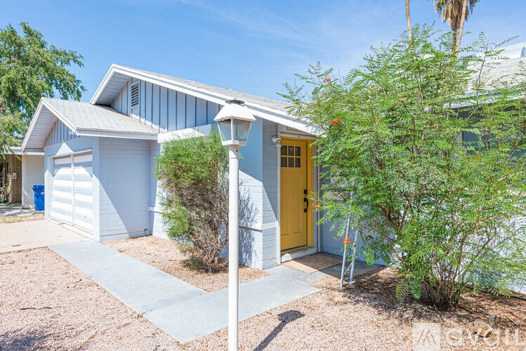 A house with a yellow door and a white lamp post.