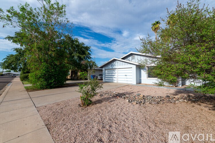 A house with a driveway and a tree in front.