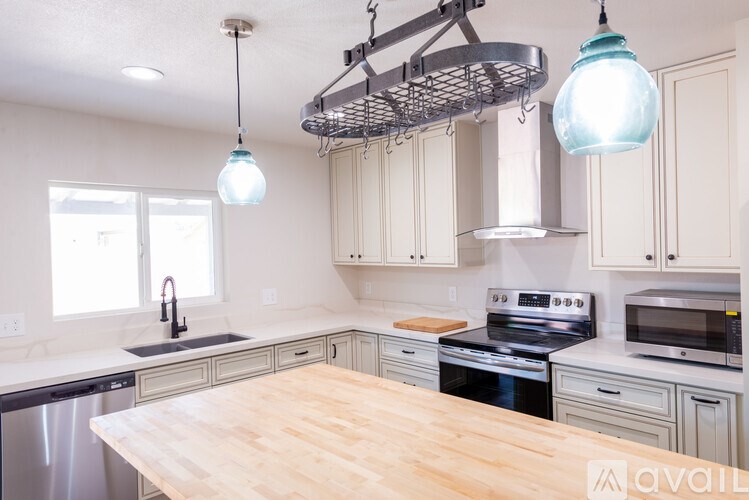 A kitchen with a wooden table and stainless steel appliances.