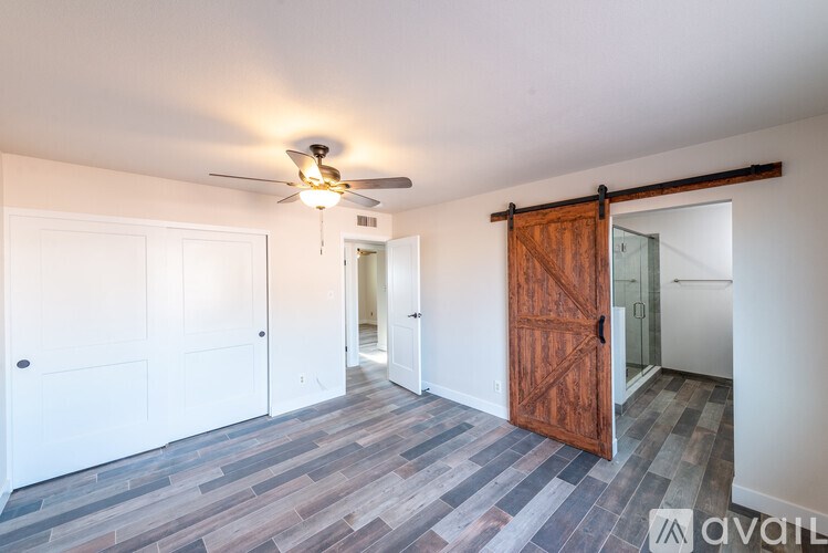 A room with a ceiling fan and a wooden door.
