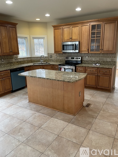 A kitchen with wooden cabinets and granite countertops.