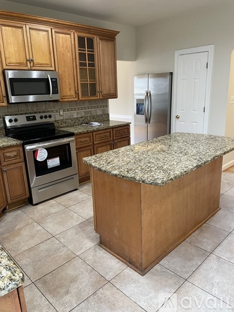 A kitchen with granite countertops and stainless steel appliances.