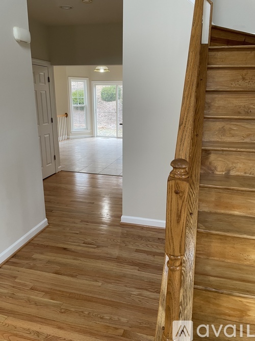 A wooden staircase leads to a bright open space.