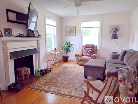 A living room with a fireplace and a television on the mantle.