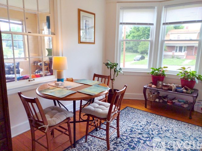 A dining room with a table and chairs.