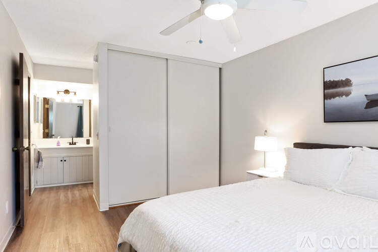 A bedroom with a large bed and a painting on the wall.