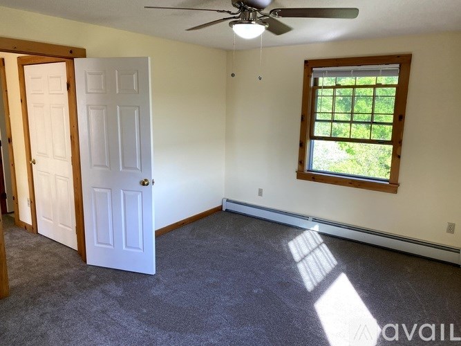 A room with a ceiling fan, a window, and a door.