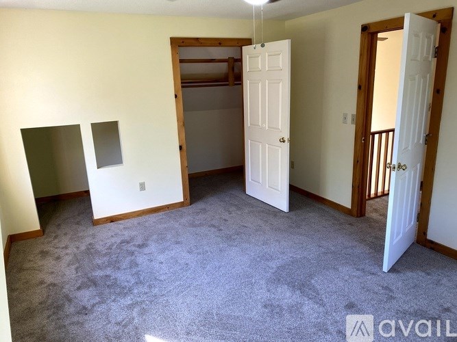 A room with a carpeted floor and a white door.