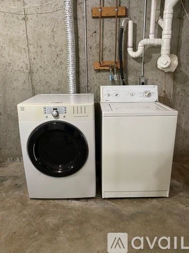 A white washing machine and dryer in a basement.