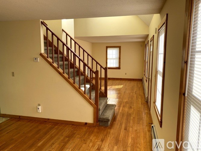 A wooden staircase leads up to a window in a house.
