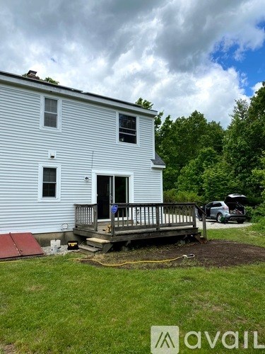 A house with a porch and a car parked in front.