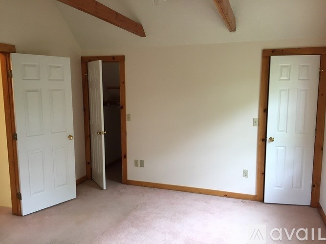 A room with two white doors and a carpeted floor.