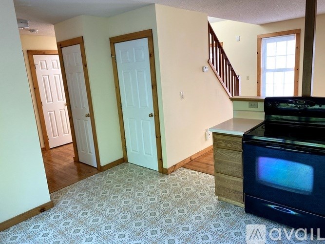 A room with a patterned carpet and a television.