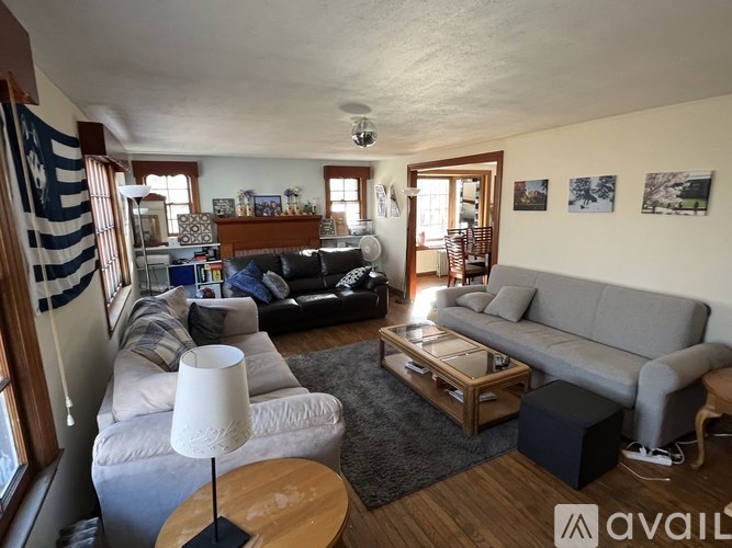 A living room with a grey couch, a white lamp, and a wooden coffee table.