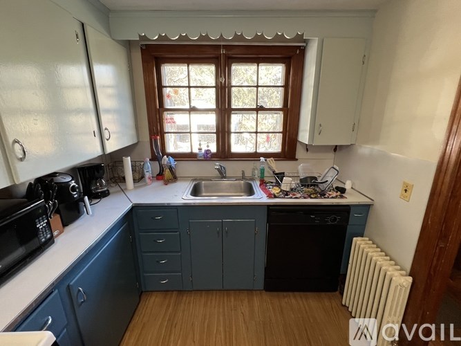 A kitchen with blue cabinets and a window.