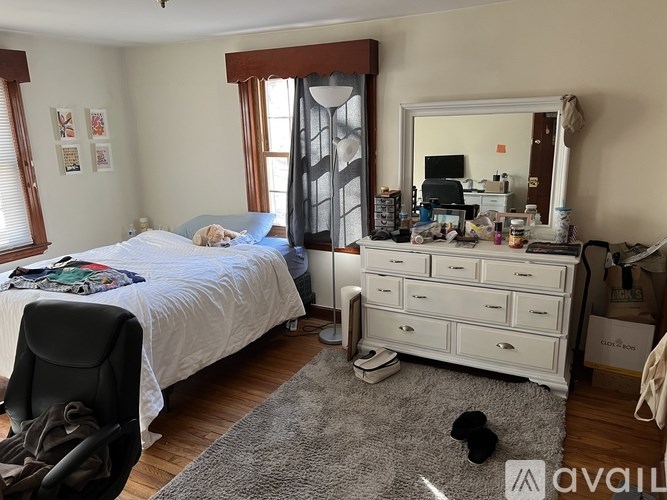 A bedroom with a bed, dresser, and chair.