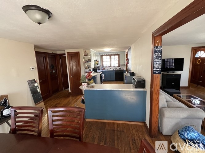 A living room with a blue bar and wooden floors.