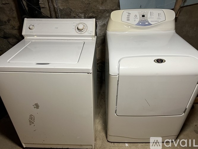 Two white washing machines are sitting next to each other.
